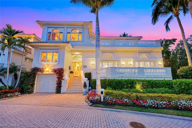 mediterranean / spanish home with a garage, decorative driveway, and stucco siding