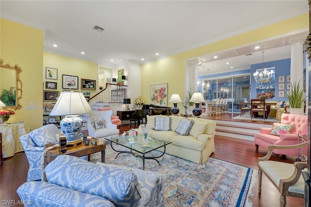 living room featuring ornamental molding, stairway, wood finished floors, and a notable chandelier