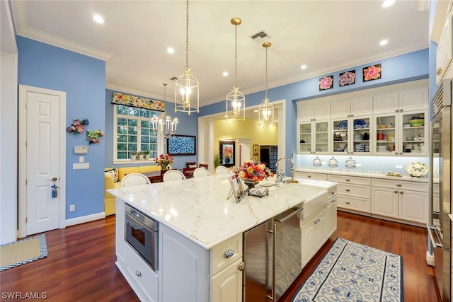 kitchen with white cabinetry, a center island with sink, dark hardwood / wood-style floors, and sink