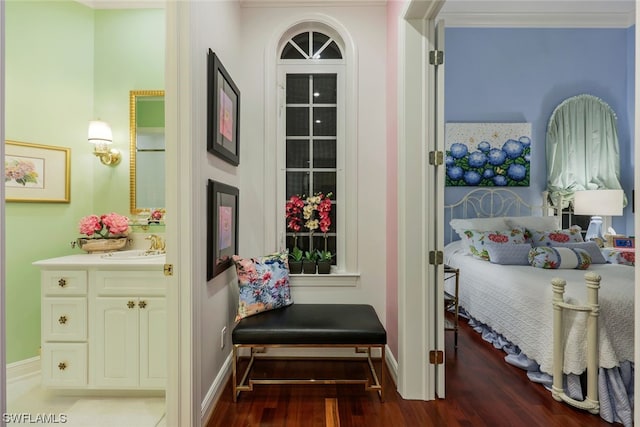 bedroom with a sink, baseboards, and wood finished floors