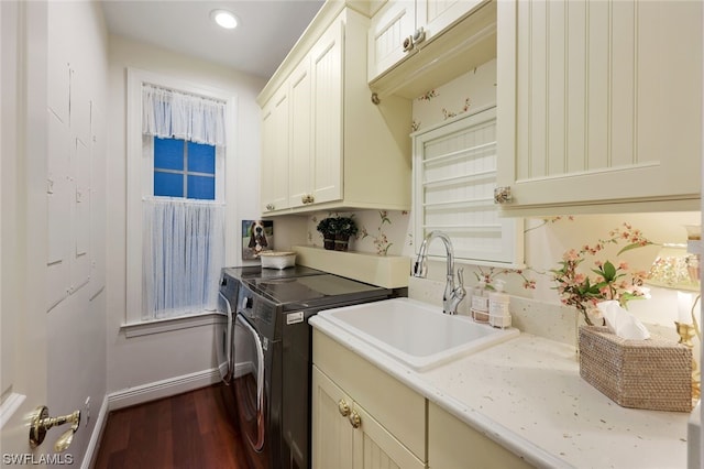 laundry room featuring dark wood-style flooring, cabinet space, a sink, independent washer and dryer, and baseboards