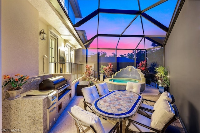 patio terrace at dusk featuring area for grilling, an in ground hot tub, and glass enclosure