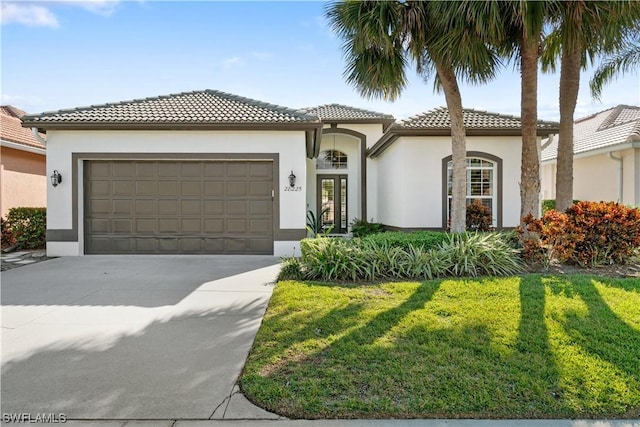 mediterranean / spanish-style house featuring a front lawn and a garage