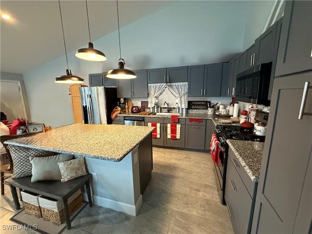 kitchen with a kitchen bar, light stone countertops, stainless steel appliances, and a sink
