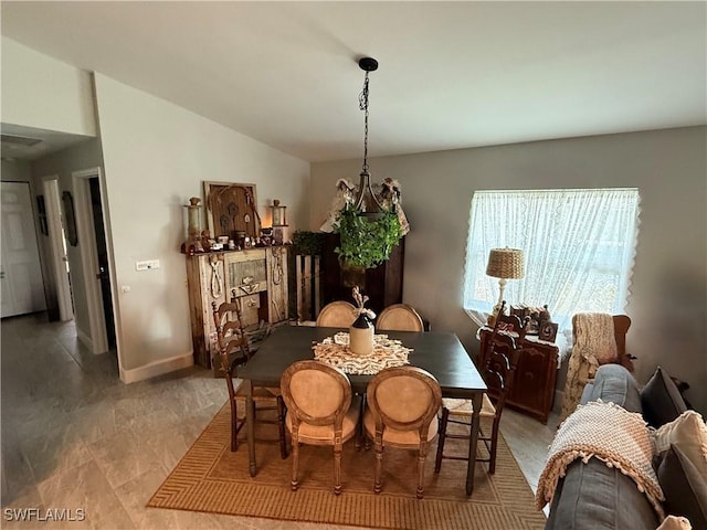 dining area featuring lofted ceiling and baseboards