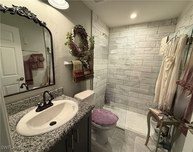 bathroom featuring recessed lighting, walk in shower, toilet, and vanity