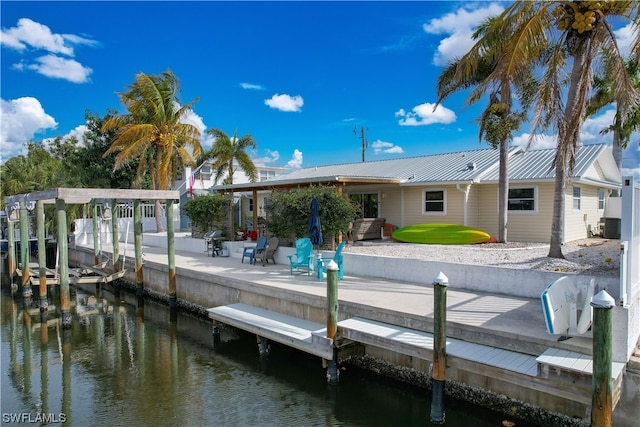 view of dock with cooling unit, a patio area, and a water view