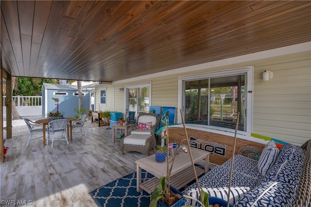 wooden terrace featuring a patio and a storage unit