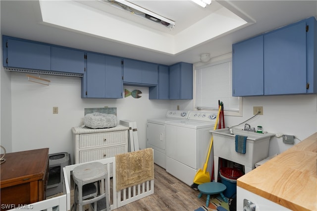 laundry room featuring cabinets, heating unit, washing machine and clothes dryer, dark wood-type flooring, and sink