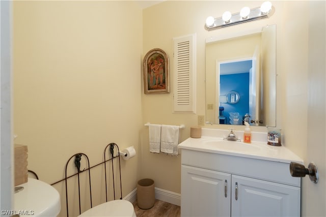 bathroom featuring vanity, hardwood / wood-style floors, and toilet