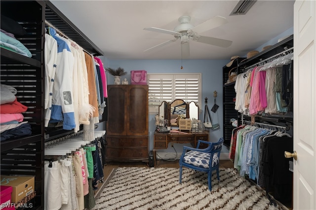 walk in closet with ceiling fan and light wood-type flooring