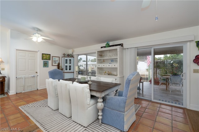 tiled dining space featuring ceiling fan and vaulted ceiling