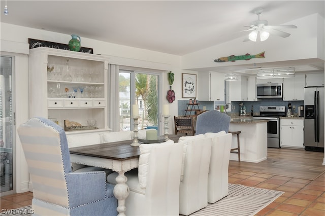 dining room featuring light hardwood / wood-style flooring, ceiling fan, and vaulted ceiling