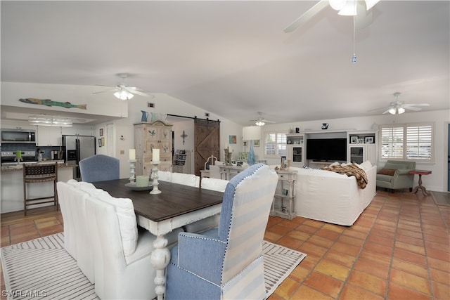 dining area featuring lofted ceiling and a barn door