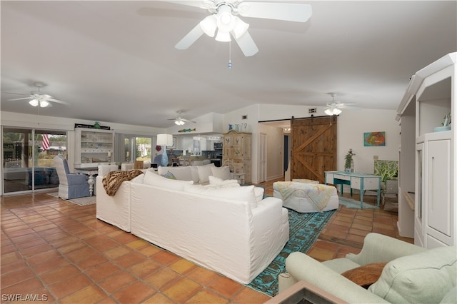 tiled living room featuring ceiling fan, lofted ceiling, and a barn door