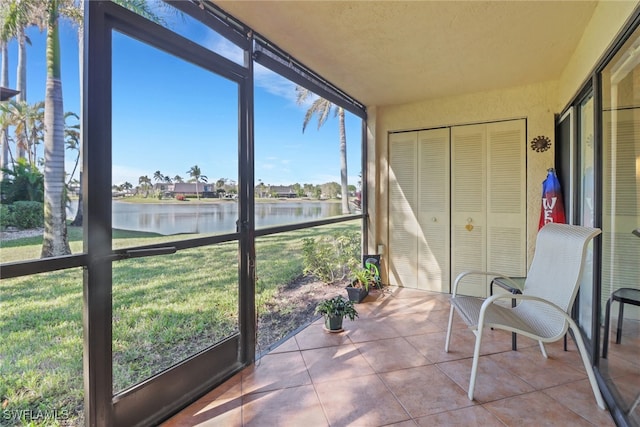 sunroom featuring a water view