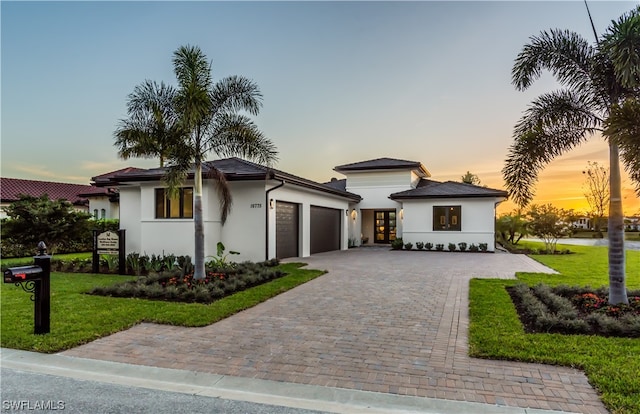 view of front of home featuring a garage and a lawn