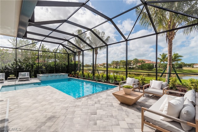 view of pool featuring a patio area, an in ground hot tub, a water view, and glass enclosure