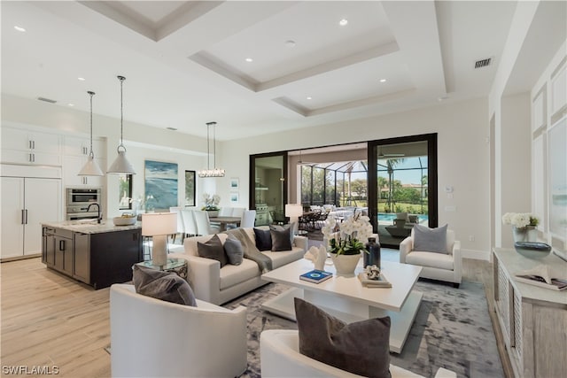 living room with coffered ceiling and light hardwood / wood-style flooring