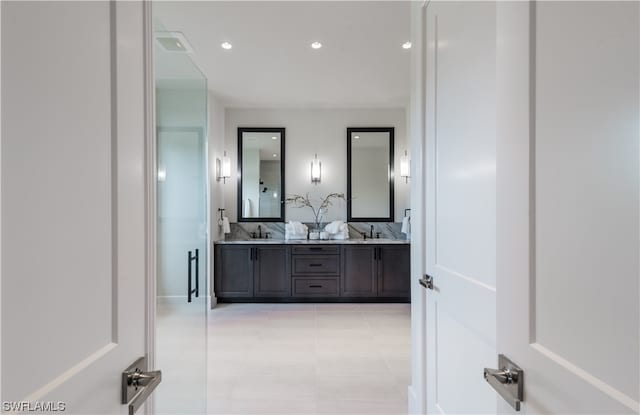 bathroom featuring tile patterned floors, vanity, and a shower with shower door