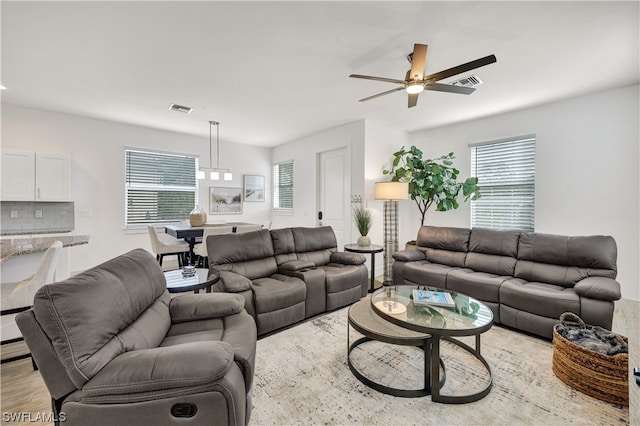 living room featuring a healthy amount of sunlight, ceiling fan, and light hardwood / wood-style flooring