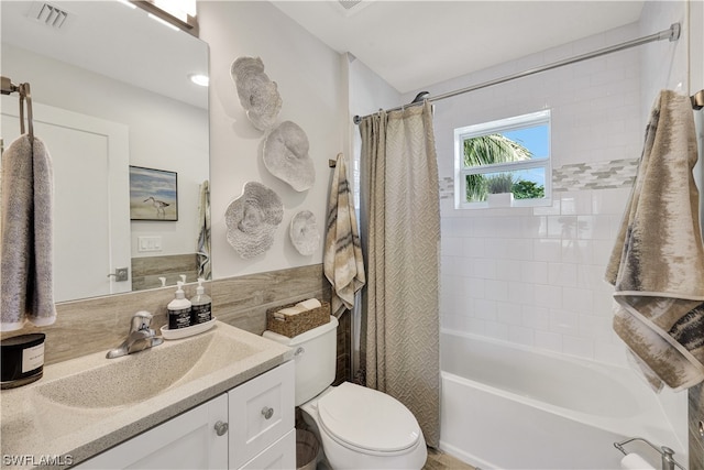 full bathroom with vanity, shower / bath combo with shower curtain, and toilet