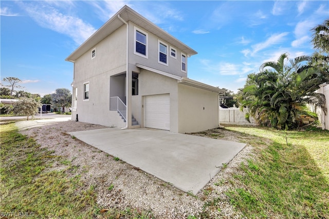 rear view of house featuring a yard and a garage