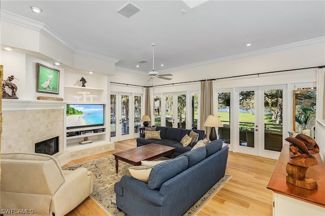 living room featuring built in features, light hardwood / wood-style floors, french doors, and ceiling fan