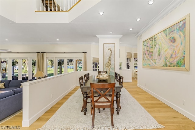 dining space featuring french doors, light hardwood / wood-style floors, and crown molding