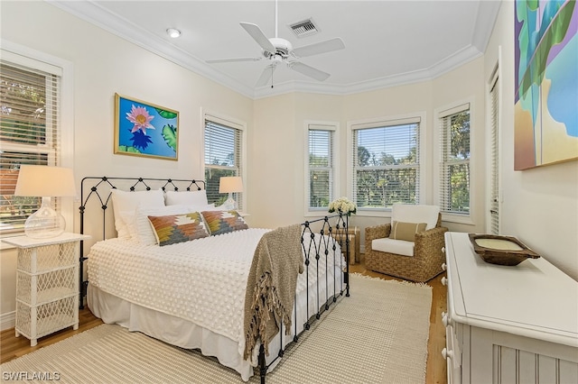 bedroom featuring ceiling fan, crown molding, and light wood-type flooring