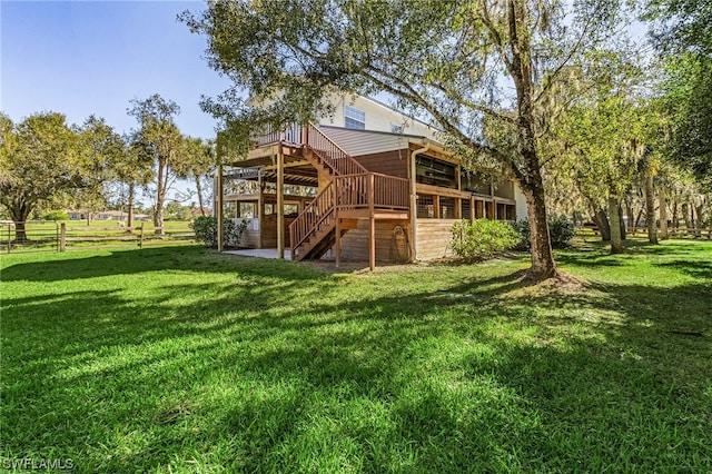 rear view of house with a yard and a deck