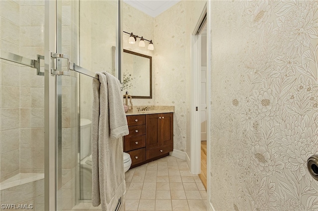 bathroom featuring ornamental molding, a shower with door, toilet, and vanity