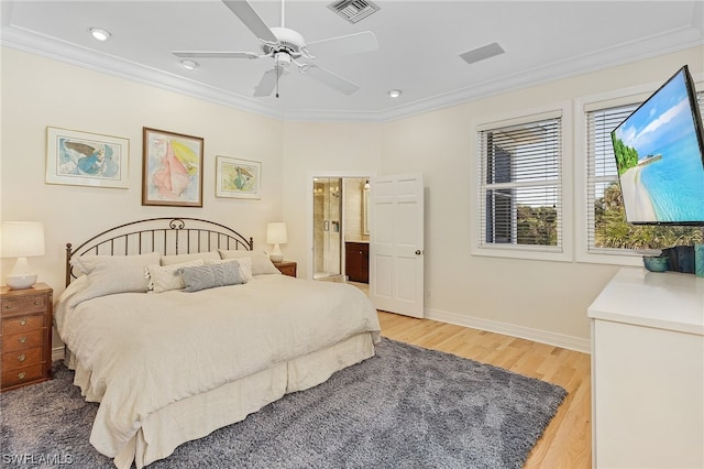 bedroom featuring ensuite bath, hardwood / wood-style floors, ceiling fan, and ornamental molding