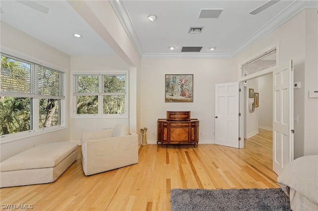 sitting room with ceiling fan, crown molding, and light wood-type flooring