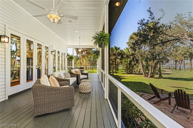 deck featuring french doors, ceiling fan, a yard, and an outdoor living space