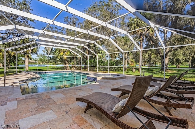 view of pool with a patio, a lawn, a lanai, and an in ground hot tub