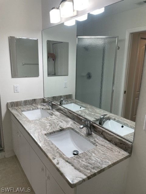 bathroom featuring walk in shower, tile floors, and dual vanity