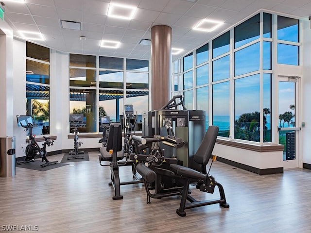 4101 Gulf Shore Blvd N Unit Ph-3, Naples, FL 34103 - exercise room featuring baseboards, wood finished floors, and a paneled ceiling