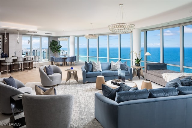 living room featuring hardwood / wood-style floors, a chandelier, and a water view