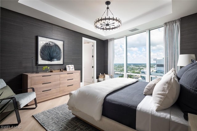 4101 Gulf Shore Blvd N Unit Ph-3, Naples, FL 34103 - bedroom with access to exterior, a raised ceiling, light wood-type flooring, visible vents, and an inviting chandelier