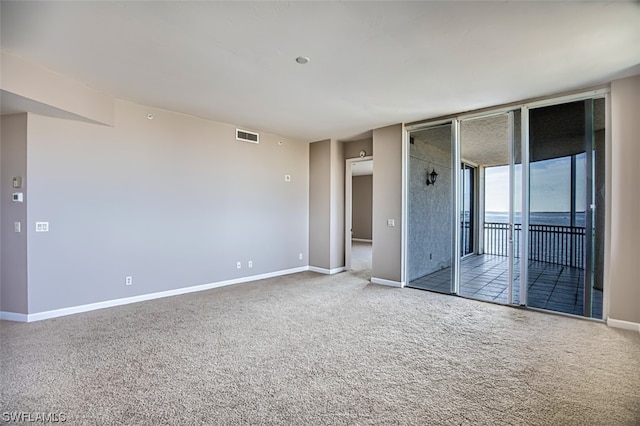 empty room with expansive windows and light carpet