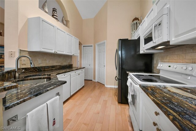 kitchen featuring white cabinets, light wood-type flooring, white appliances, and sink