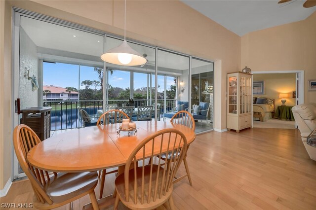 dining room featuring ceiling fan, light hardwood / wood-style floors, and a water view