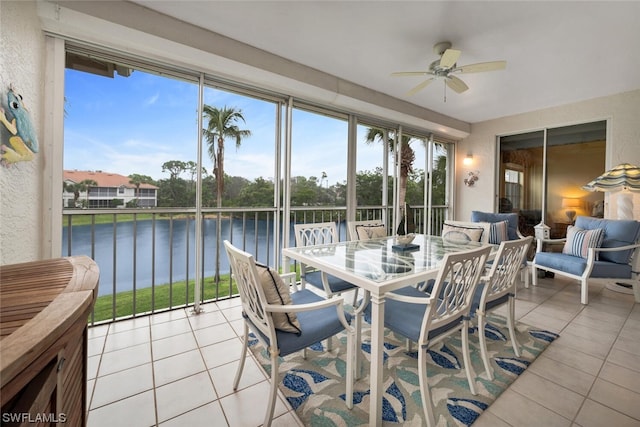 sunroom / solarium featuring ceiling fan and a water view