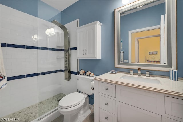 bathroom featuring tiled shower, vanity, and toilet