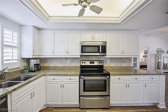 kitchen with light wood-type flooring, stainless steel appliances, and white cabinets
