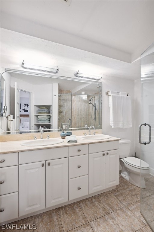bathroom featuring vanity, a shower with shower door, toilet, and tile patterned floors