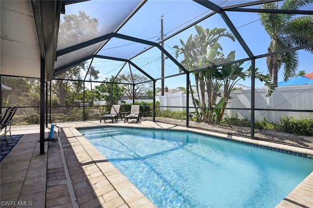 view of pool featuring glass enclosure and a patio