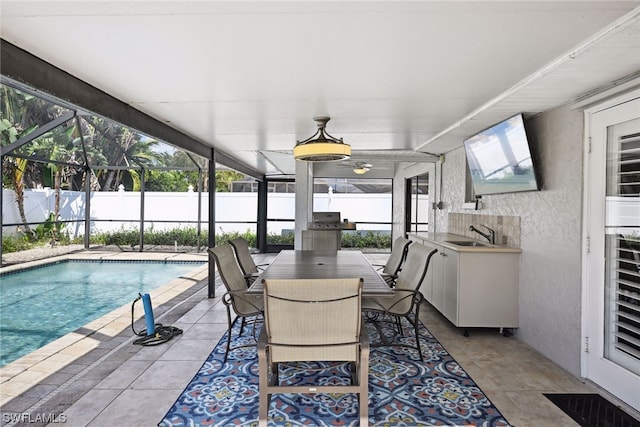 view of pool featuring glass enclosure, ceiling fan, a patio area, and sink