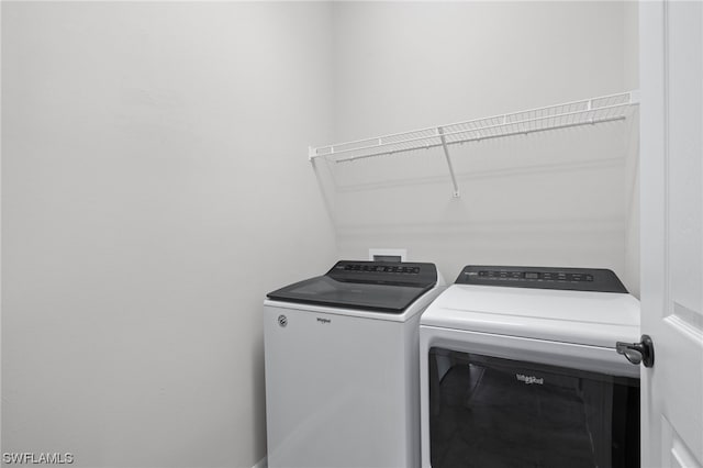 clothes washing area featuring separate washer and dryer